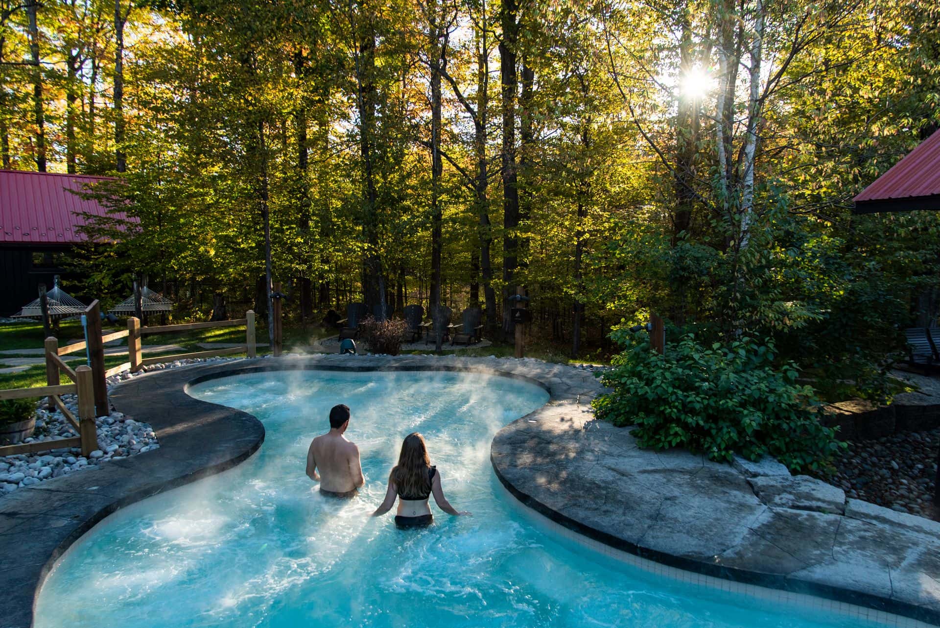 A couple walking through the heated pools on a Fall afternoon at Scandinave Spa in Craigleith.
