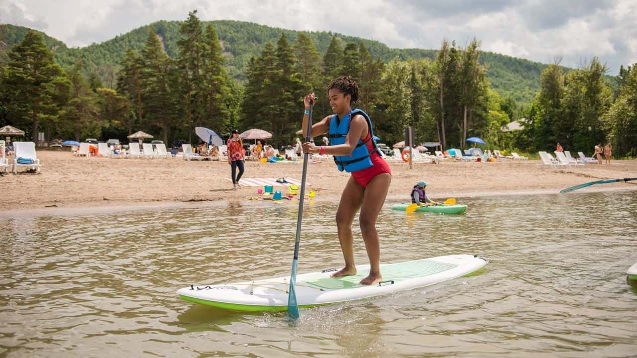 A lady on a stand up paddleboard on Blue Mountain Private Beach.