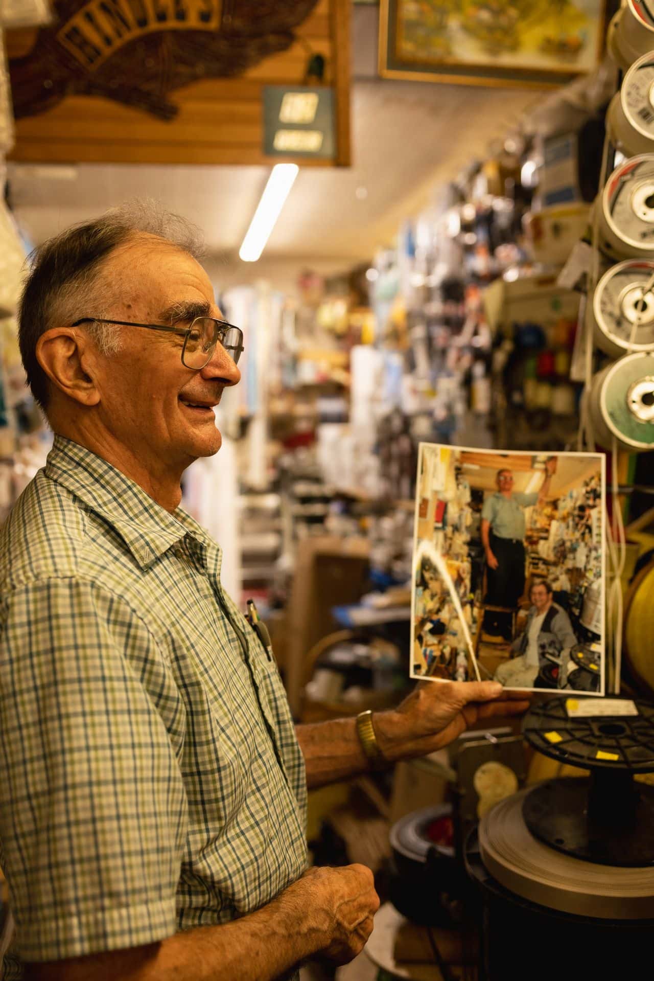 Local icon and owner of Hindel's Hardware in Clarksburg, James Hindel give us a smiling pose while holding up a photo from 1971 when he opened the shop.
