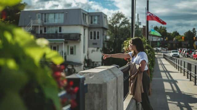 Two friends point as they look over the Thornbury Bridge at the fish jumping up stream during the annual salmon run
