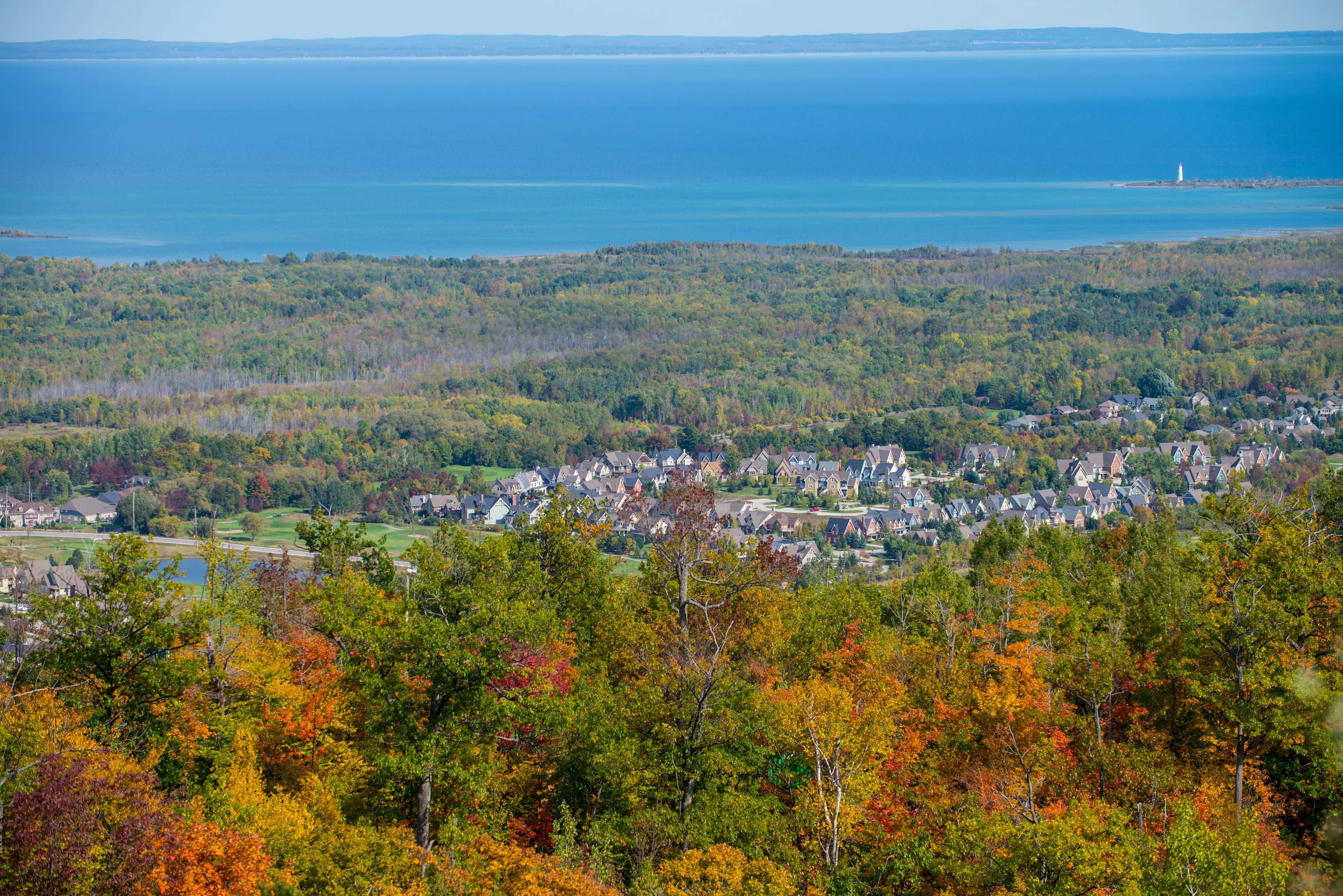 Stunning view of the autumn forests, residential community, and South Georgian Bay from the top of Blue Mountain Resort in Fall