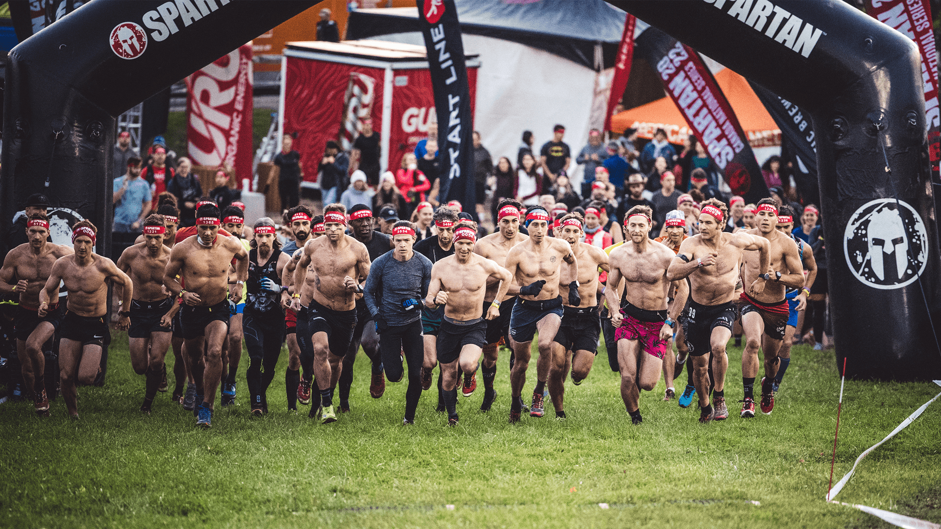 A huge group of endurance athletes running off the start line for the Spartan Trifecta weekend at Blue Mountain Resort.