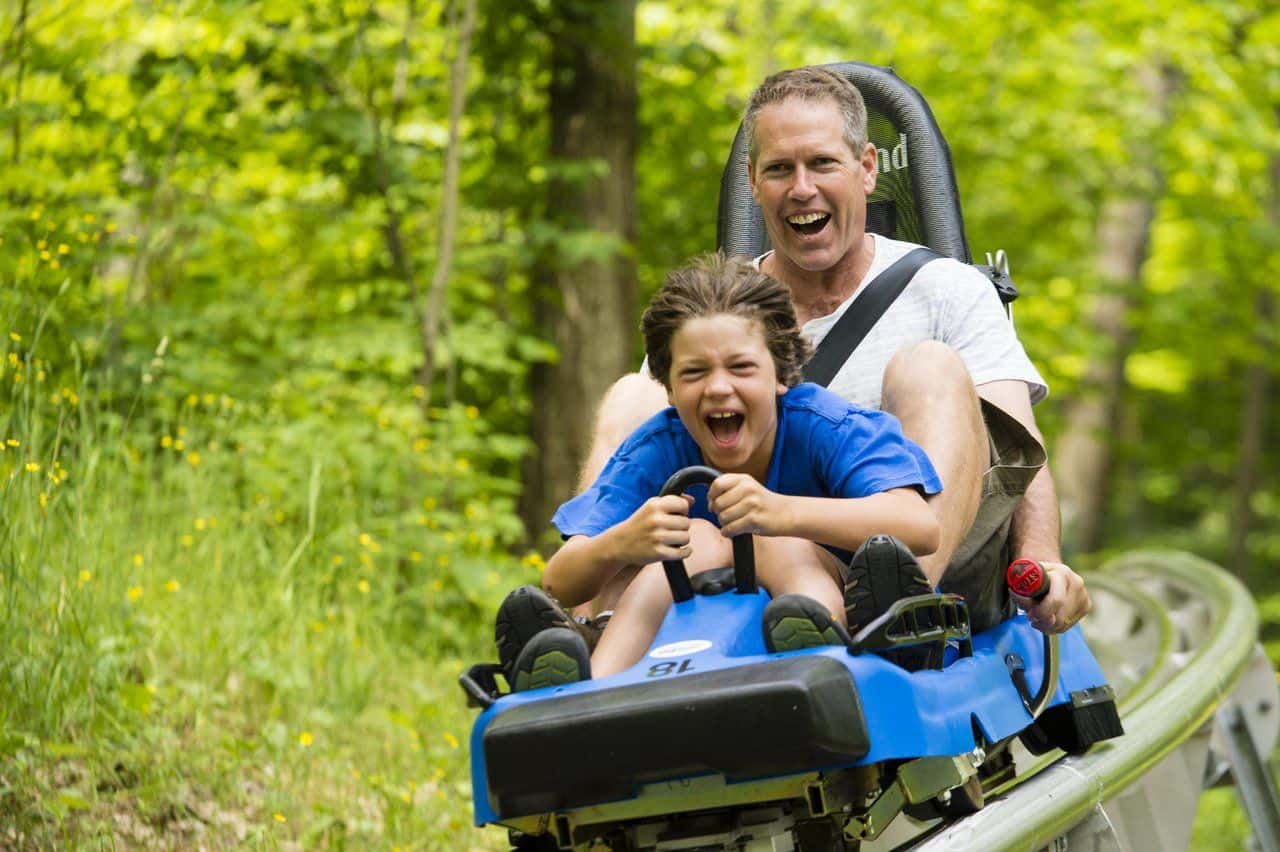 A father and son cruise down the ridge runner coaster at Blue Mountain Resort