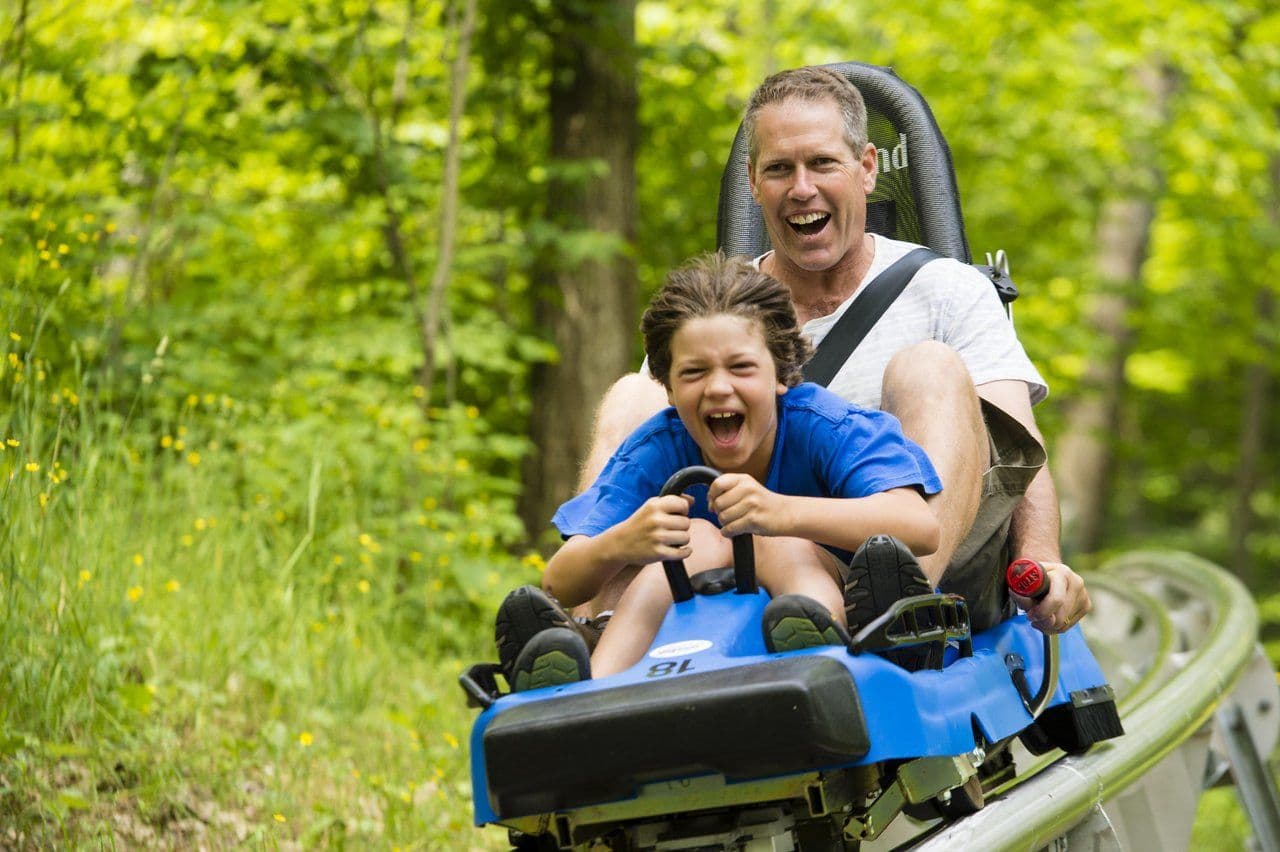 A father and son cruise down the ridge runner coaster at Blue Mountain Resort