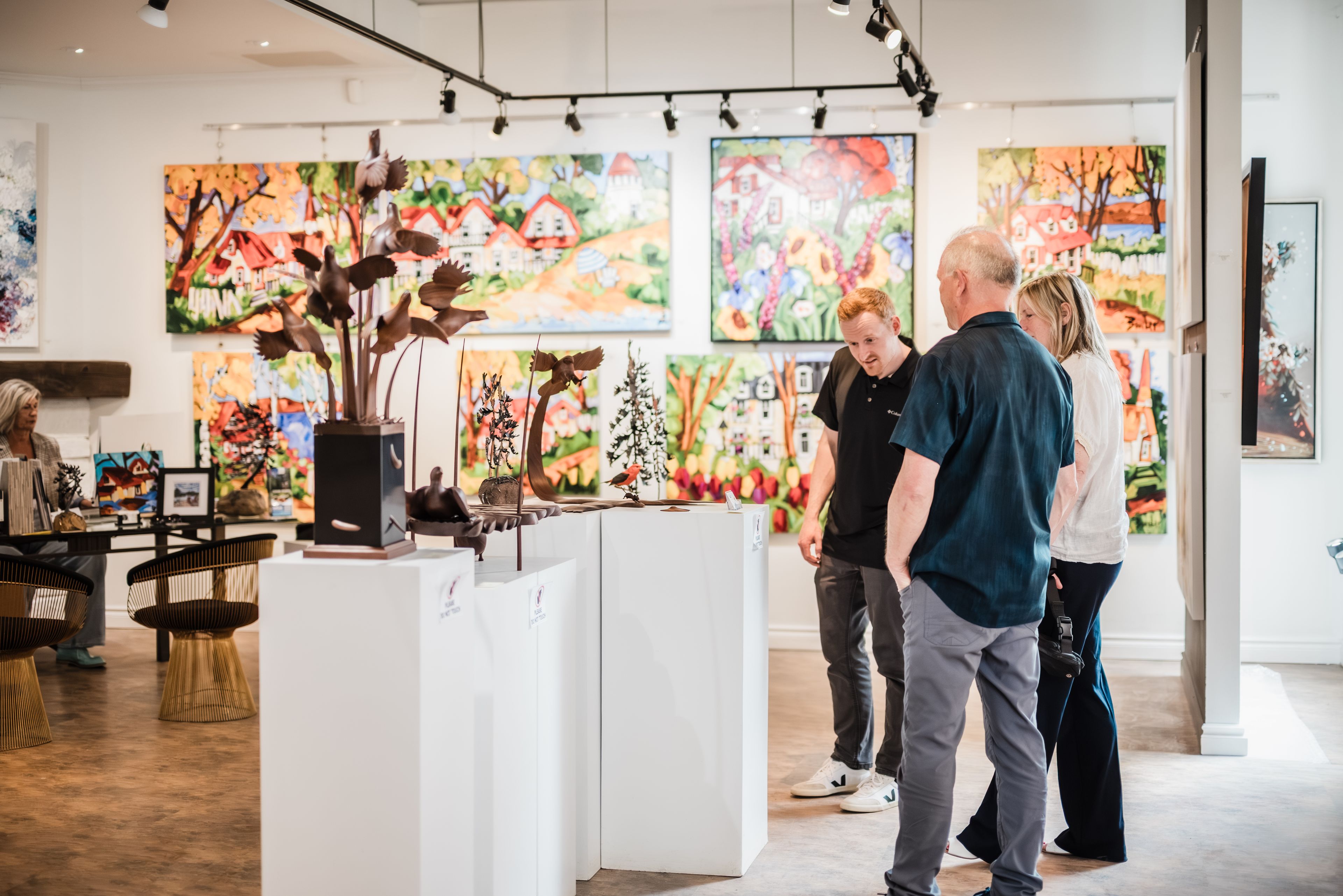 Two shoppers learning about one of the Canadian Artists at the Bright's Gallery in Blue Mountain Village.