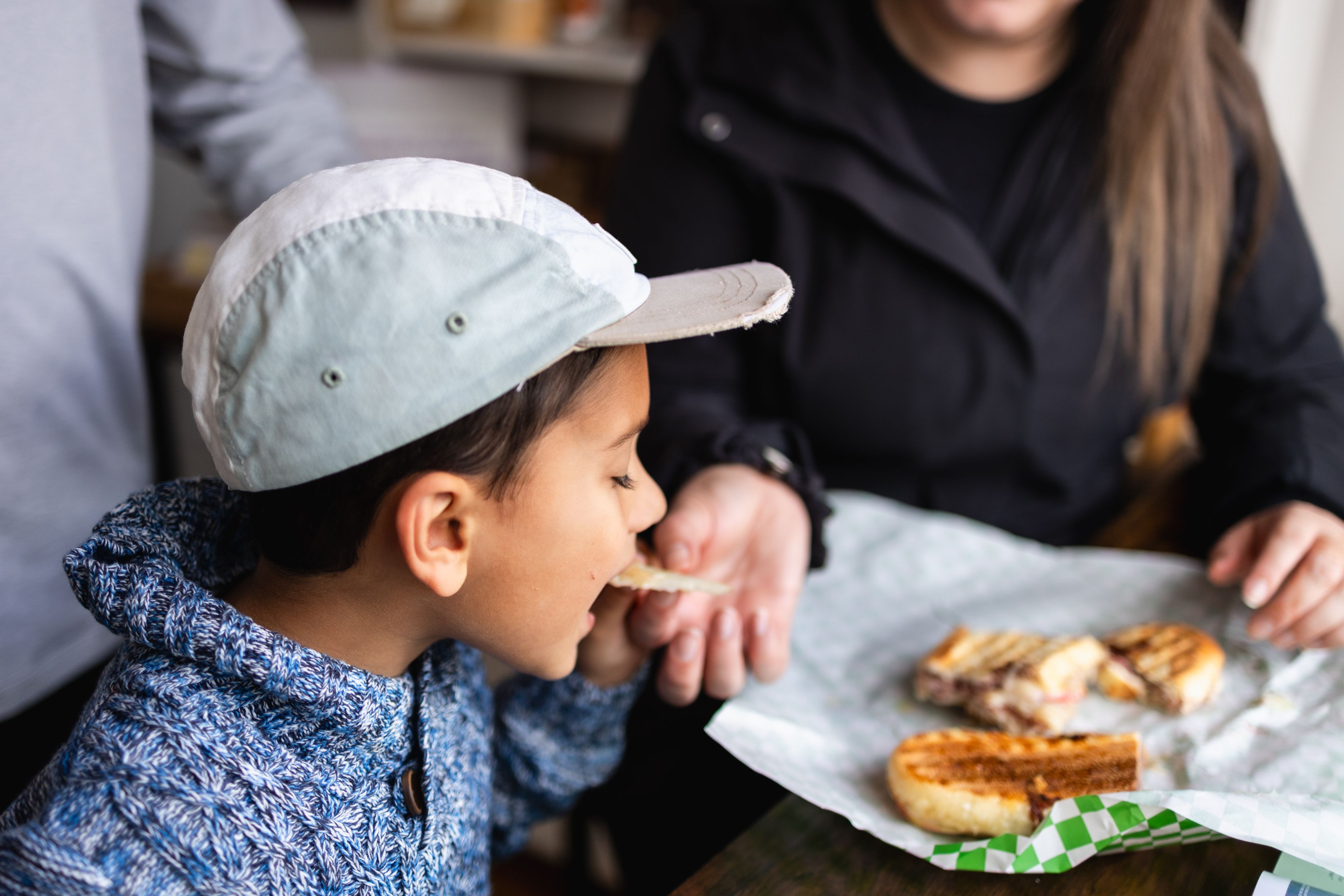 A mom feeding her young boy a delicious fresh made sandwich from the Market on Marsh in Clarksburg