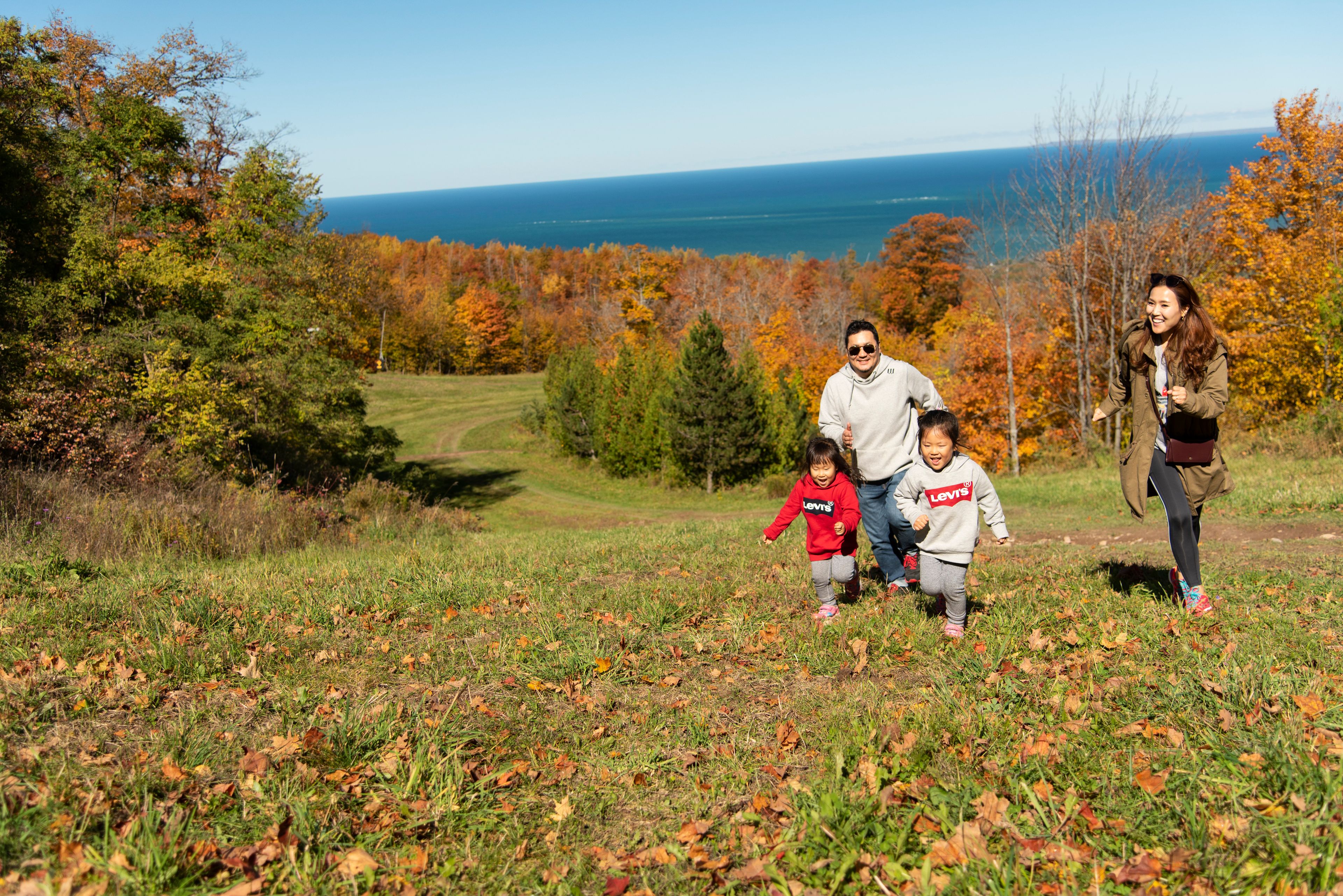 Parents chase their two young girls as they run up the Blue Mountain slopes on a sunny fall afternoon
