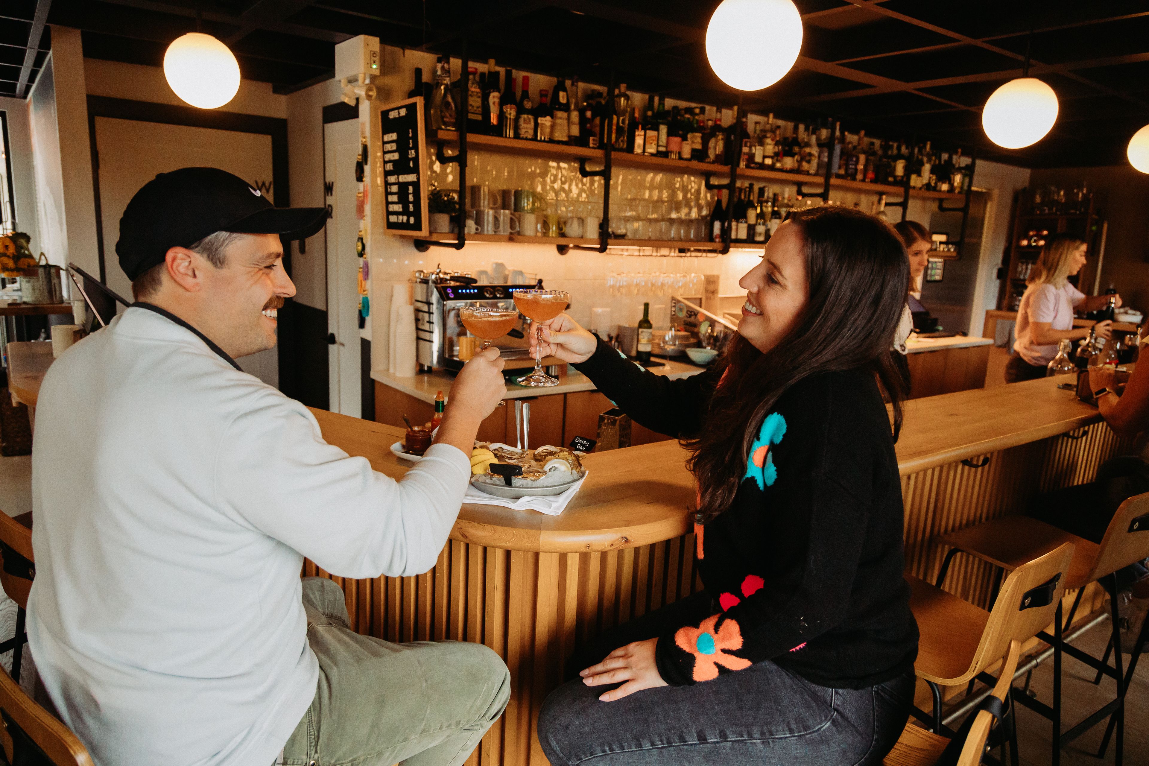 A picture of a couple having cocktails in the Penny's Motel bar. 