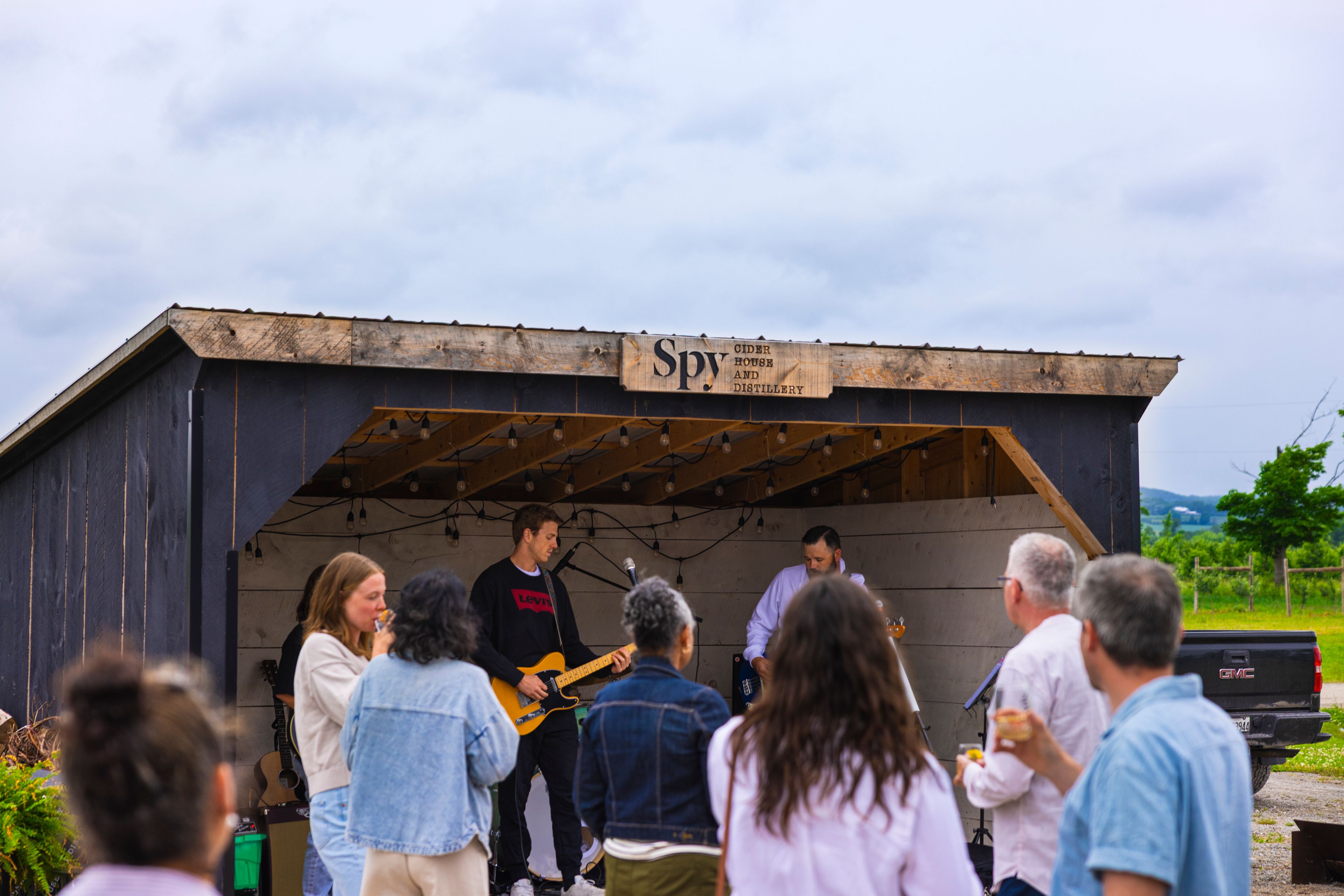A photo of a group of people dancing and watching a band play at Spy Cider.